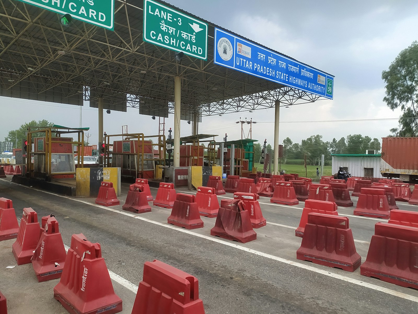 A highway toll plaza with barriers and lanes, representing Cloudflare's move to meter and charge AI crawlers at the network edge