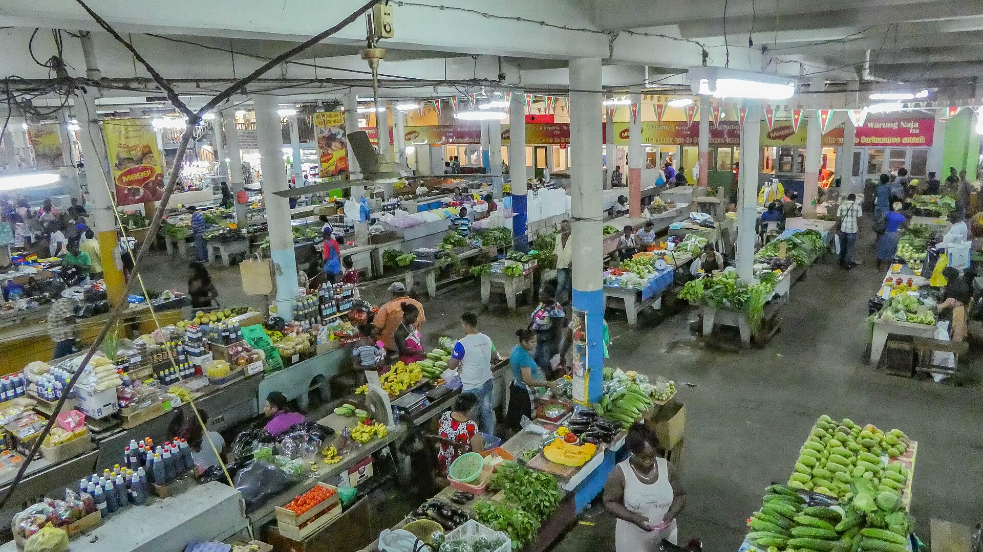 Shoppers and vendors at a covered market in Paramaribo, Suriname, where fresh poultry and produce are sold